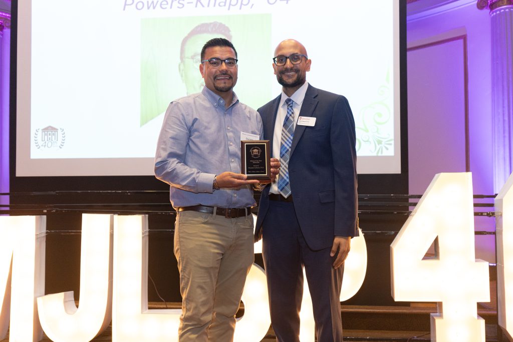 Portrait of two men holding an award